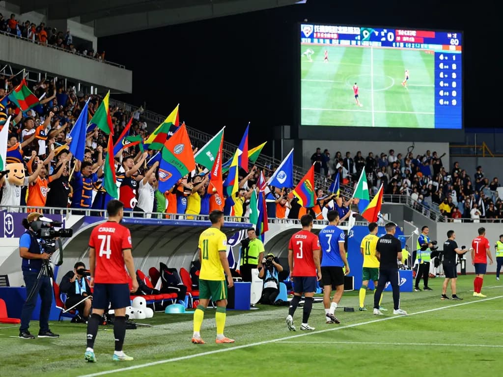 Fans cheering passionately during a soccer match with live nowgoal scores displayed.